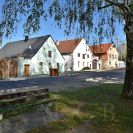 Roudné: usedlosti na severní straně návsi u mostu; zprava: čp. 33 (dům datován 1887), čp. 5 s branou (dům datován 1902), čp. 8 s branou, postsecesní dům čp. 4; foto Nebe 2018.