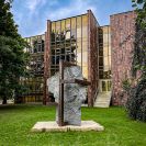 Sochařství: socha stojící za budou Jihočeské vědecké knihovny od Václava Fialy s názvem Hlava II, socha pro Lawrence Ferlinghettiho; foto Nebe 2021.