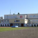 Sokolovny: pohled z východní tribuny stadionu na rekonstruovanou sokolovnu a škvárovou dráhou 2005; archiv T. J. Sokol ČB.