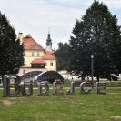 Sokolský ostrov: pohled na lávku přes Slepé rameno k Solní brance, v popředí nápis „Budějce“ od Michala Trpáka, součást výstavy Umění ve městě 2019; foto Nebe 2019.
