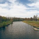 Vltava (řeka): pohled z lávky u Meteoru směrem po proudu řeky, vpravo molo a výstupní místo pro kemp Meteor, v pozadí vlevo Stecherův mlýn; foto Nebe 2025.