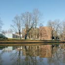 Malše: pohled na budovu Muzea dělnického revolučního hnutí (Jihočeské vědecké knihovny) přes řeku, kvůli ideově důležité stavbě z roku 1975 bylo tehdy zbořeno 11 domů na nábřeží Malše; foto Nebe 2026.