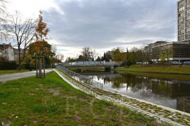 Malše: pohled k mostu Kosmonautů z parku Dukelská, kde byl při revitalizaci v letech 2022–2023 vybudován otevřený přístup k řece ve formě dvou širokých schodů; foto NEBE 2023.
